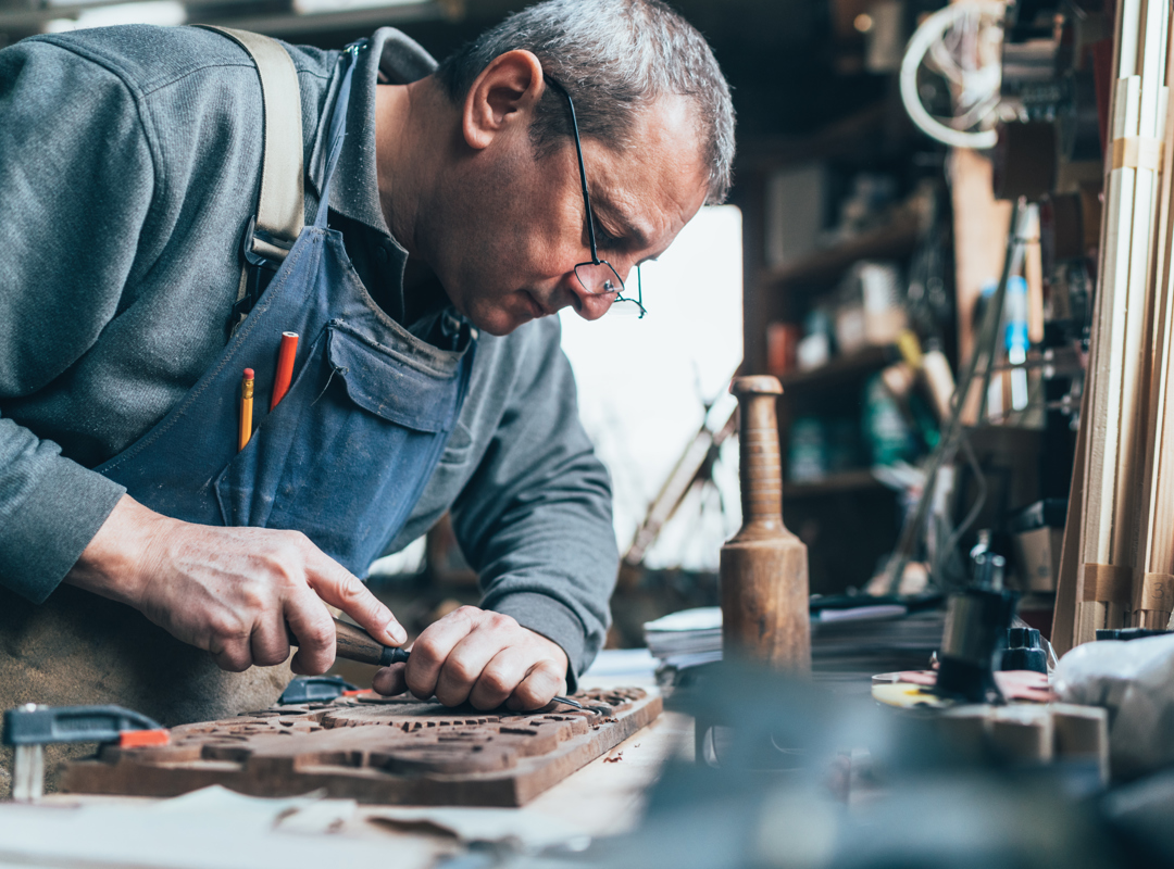 Person Chiselling At Workbench