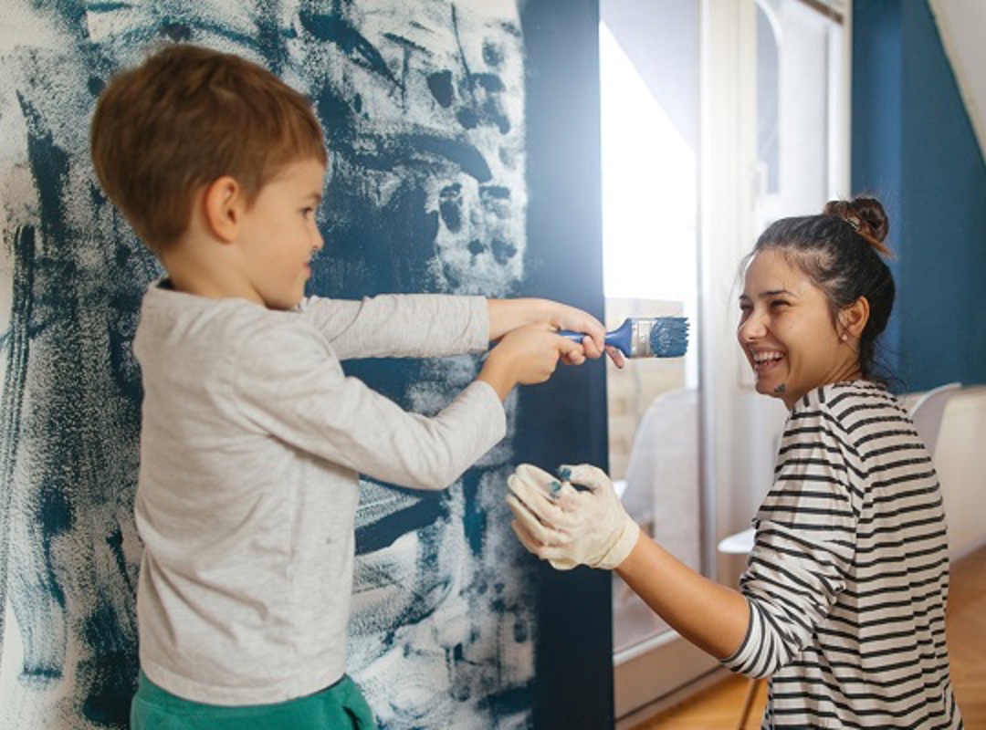 Mother And Son Painting A Room