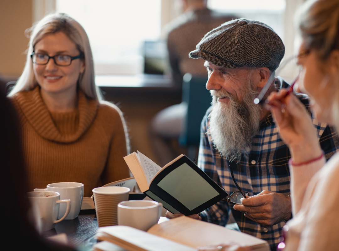 Group Reading Together In A Cafe